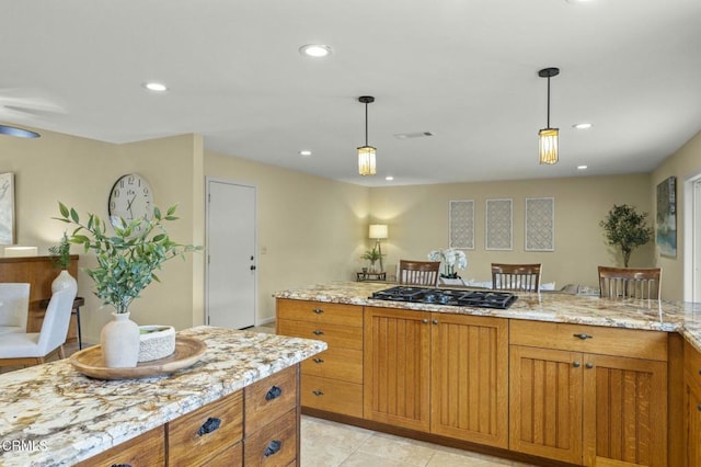 kitchen with light stone counters, recessed lighting, brown cabinets, black gas stovetop, and hanging light fixtures