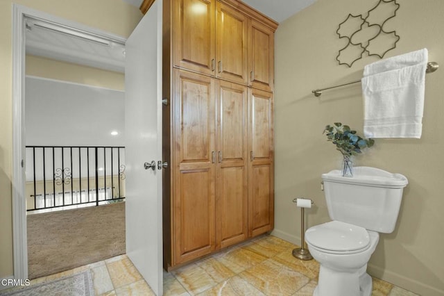 bathroom featuring toilet and baseboards