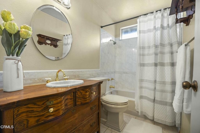 full bathroom with vanity, shower / bath combo with shower curtain, tile walls, toilet, and tile patterned floors