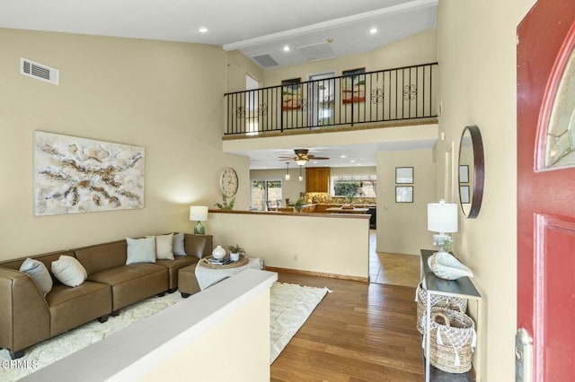 living room with wood finished floors, visible vents, high vaulted ceiling, beam ceiling, and recessed lighting