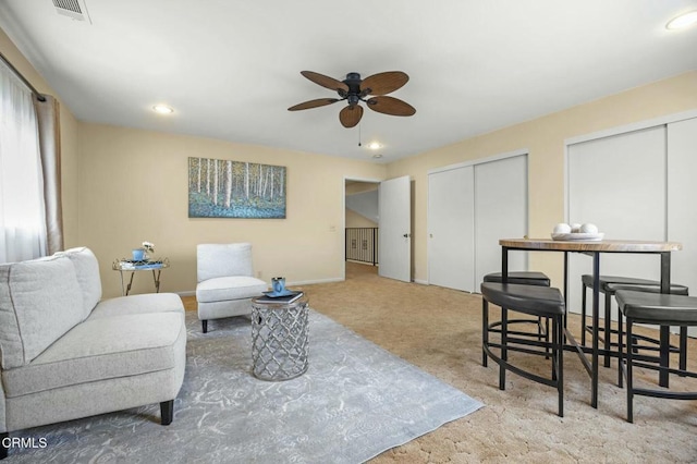 living area featuring baseboards, visible vents, recessed lighting, ceiling fan, and carpet flooring