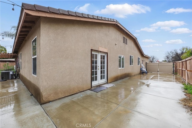 back of house with a patio area, central AC unit, french doors, and stucco siding