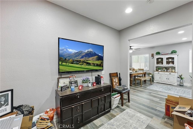 living area with recessed lighting, light wood-style floors, ceiling fan, and a textured wall