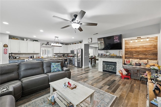 living room featuring visible vents, dark wood-style floors, recessed lighting, a brick fireplace, and ceiling fan