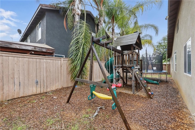 view of playground featuring a trampoline and fence