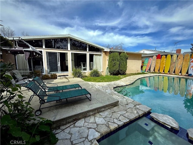 view of pool featuring a pool with connected hot tub, a patio, and fence