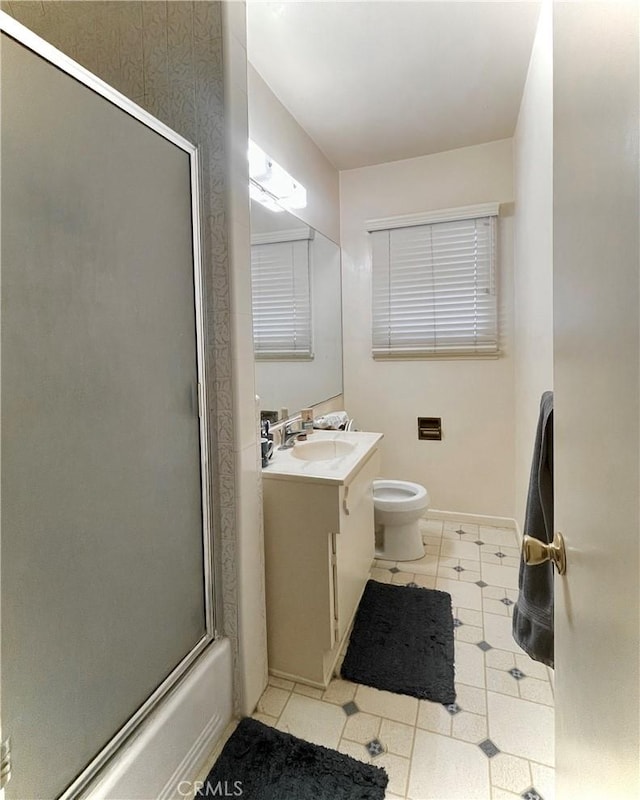 bathroom with vanity, toilet, and baseboards