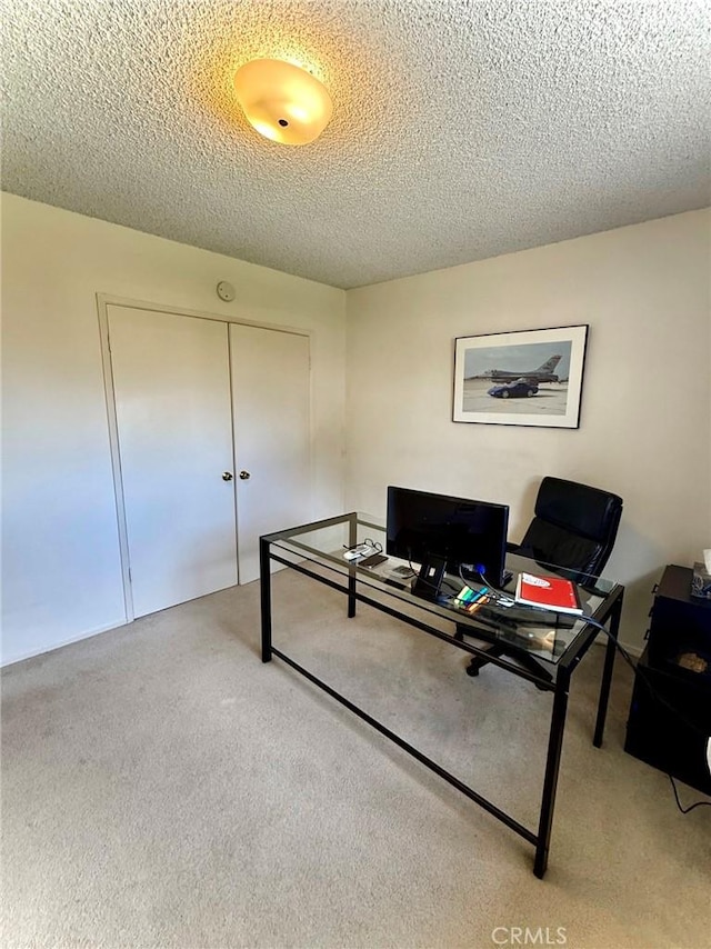 home office with light colored carpet and a textured ceiling