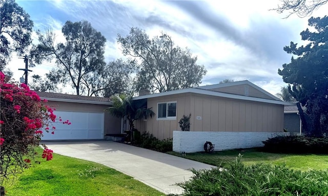 view of front of home featuring brick siding, a garage, concrete driveway, and a front lawn