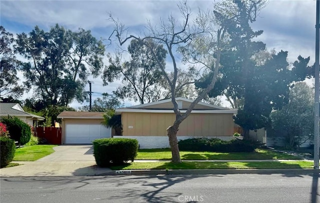 view of front of property with a front lawn, a garage, brick siding, and driveway