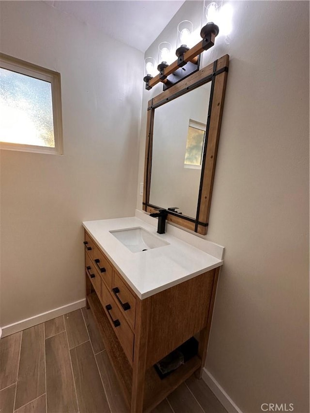 bathroom featuring baseboards, wood tiled floor, and vanity