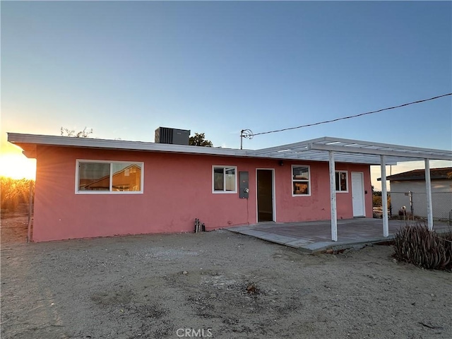 rear view of property with central AC unit, stucco siding, and a patio