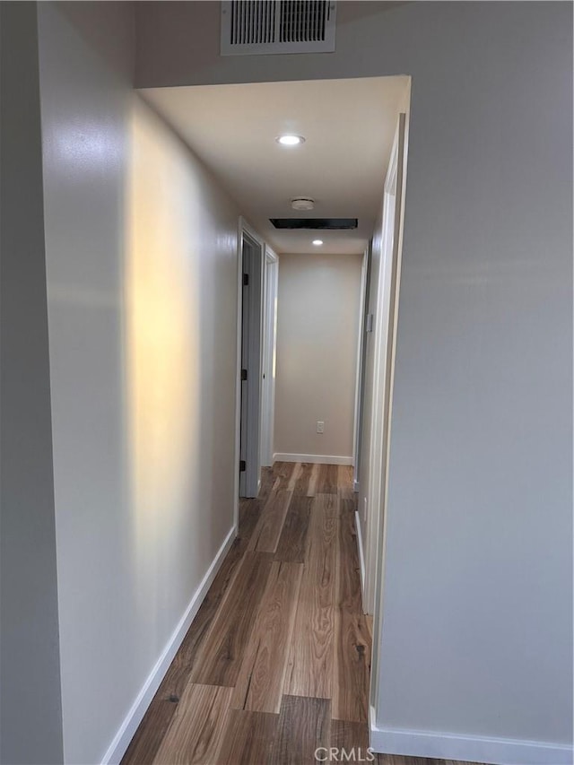 corridor with visible vents, recessed lighting, baseboards, and wood finished floors