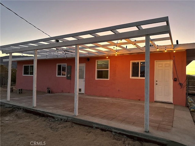 rear view of house featuring a patio and stucco siding