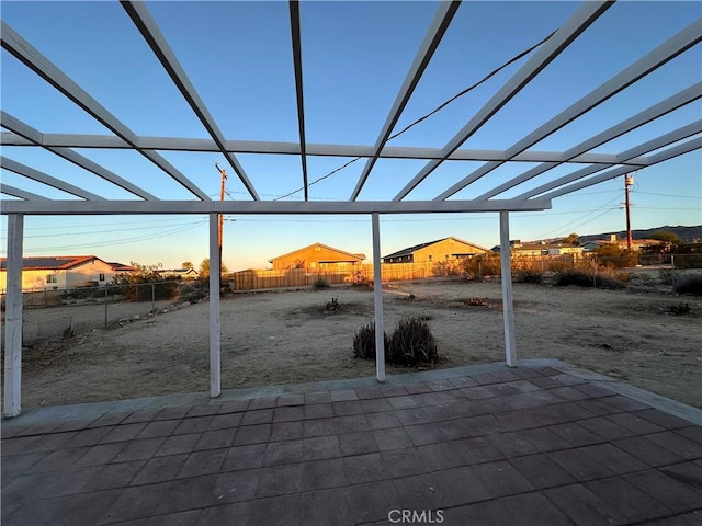 patio terrace at dusk with glass enclosure and a fenced backyard