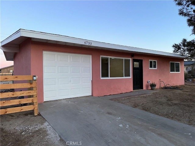 view of front facade featuring a garage, driveway, and stucco siding