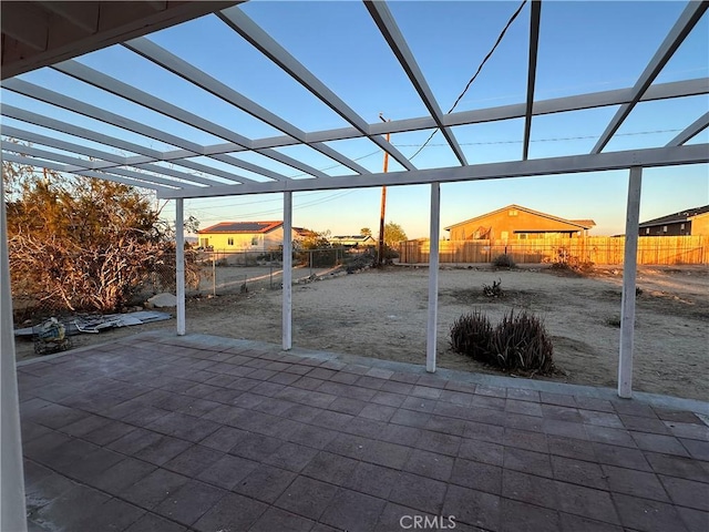 patio terrace at dusk with a lanai and fence