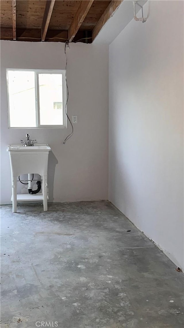 spare room with beam ceiling, wood ceiling, and unfinished concrete floors