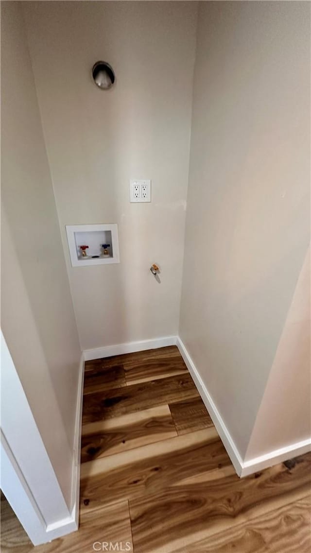 laundry room with baseboards, wood finished floors, hookup for a washing machine, and laundry area