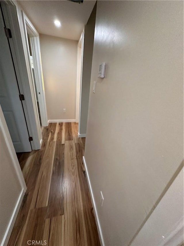 hallway with recessed lighting, baseboards, and wood finished floors