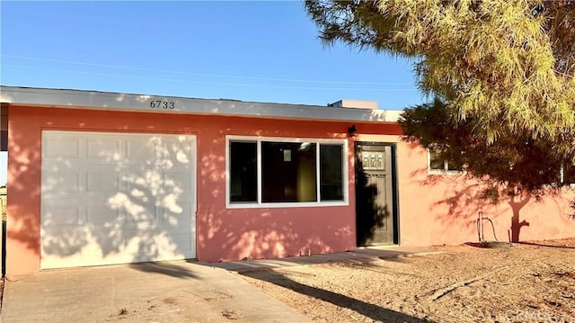 view of front of home with stucco siding and concrete driveway