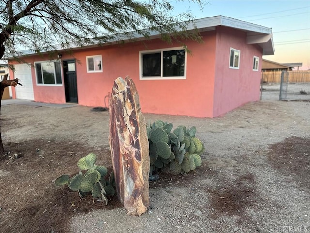 back of property with stucco siding and fence