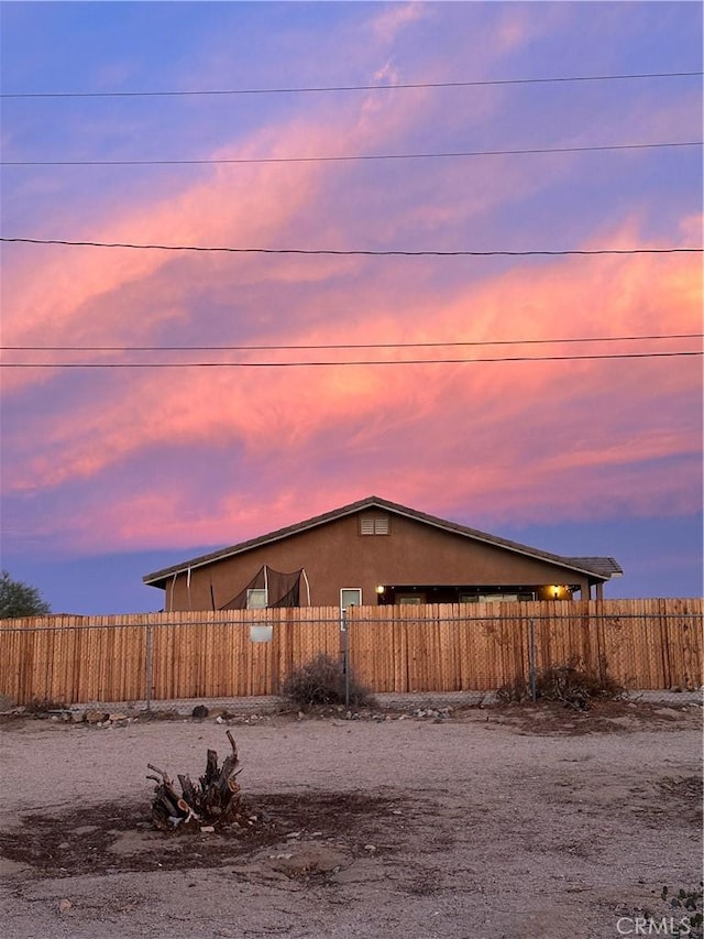 view of property exterior with stucco siding and fence