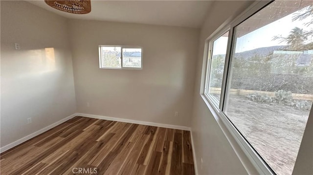 spare room featuring wood finished floors and baseboards