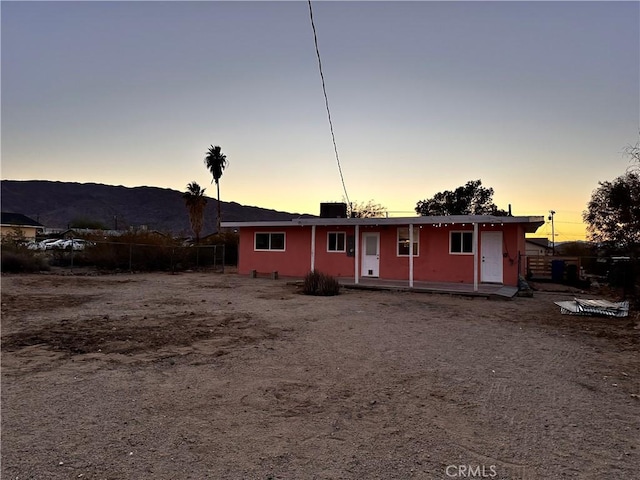 back of house at dusk featuring a porch