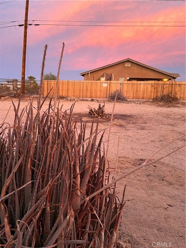 yard at dusk with a fenced backyard