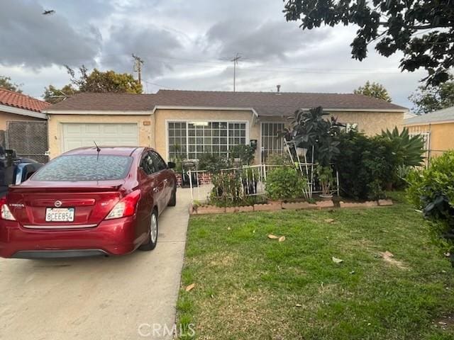 single story home with a front lawn, an attached garage, driveway, and stucco siding