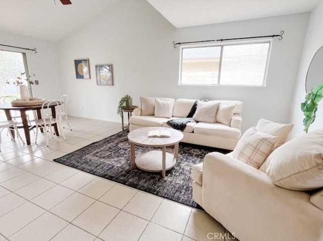 living area with vaulted ceiling, light tile patterned floors, and ceiling fan