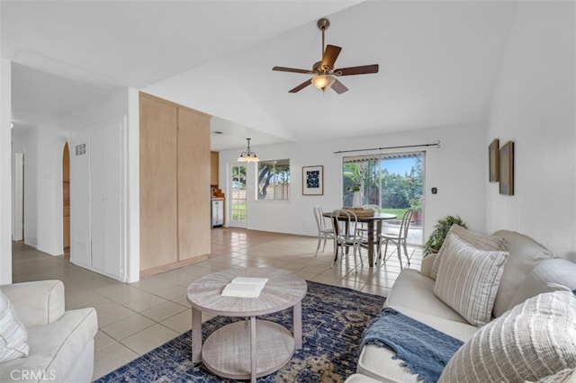 living room featuring ceiling fan with notable chandelier, light tile patterned floors, a healthy amount of sunlight, and high vaulted ceiling