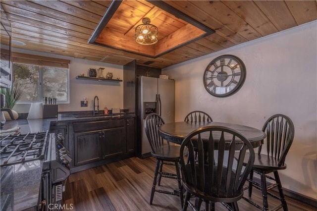 dining space featuring indoor wet bar, a raised ceiling, wooden ceiling, and dark wood finished floors