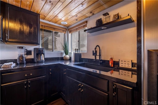 kitchen with wooden ceiling, dark countertops, open shelves, and a sink