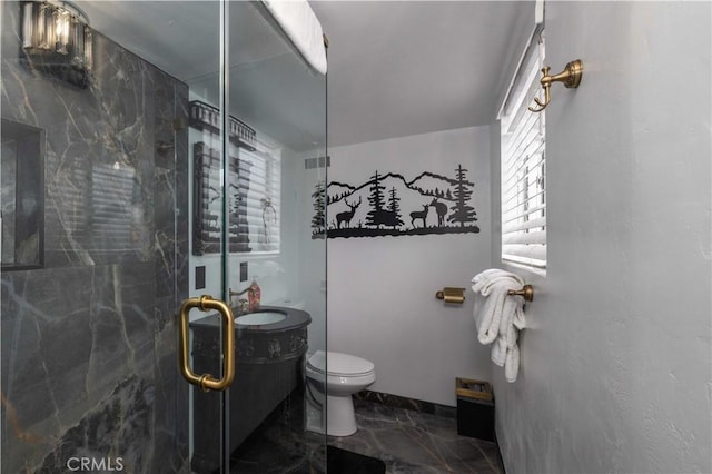 full bathroom featuring a shower stall, toilet, and marble finish floor