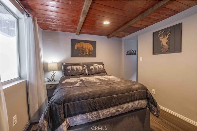 bedroom featuring beam ceiling, wood finished floors, wood ceiling, and baseboards