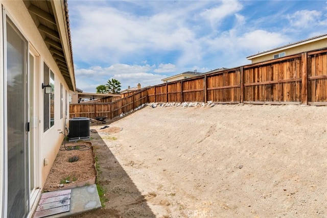 view of yard with central air condition unit and a fenced backyard