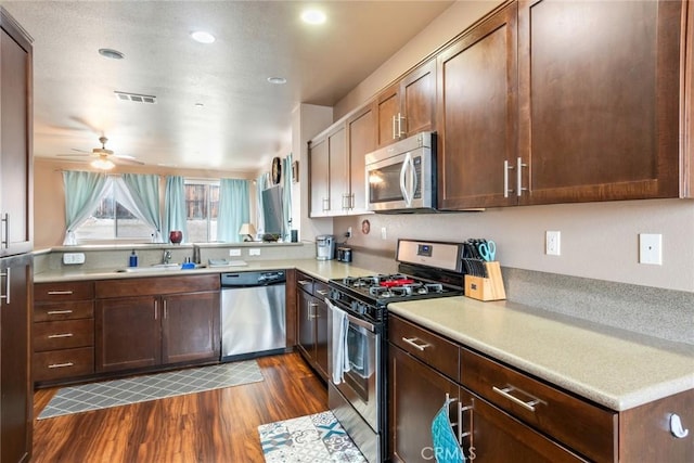 kitchen with visible vents, dark wood finished floors, light countertops, stainless steel appliances, and a sink