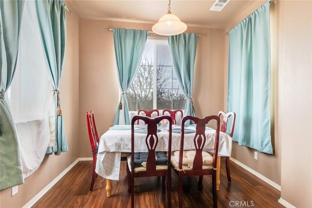 dining space with visible vents, baseboards, and wood finished floors