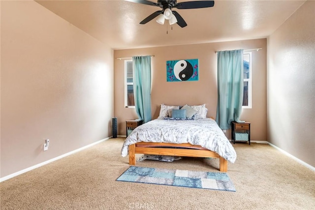 carpeted bedroom with a ceiling fan and baseboards