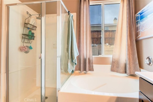 full bath with vanity, a bath, and a shower stall