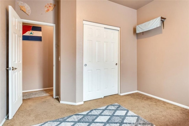 carpeted bedroom featuring baseboards and a closet