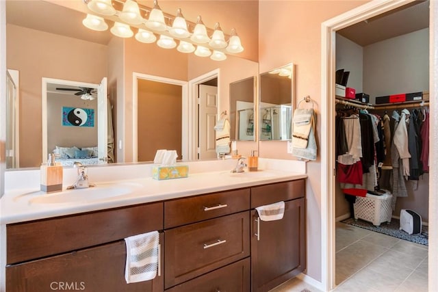 ensuite bathroom featuring a sink, connected bathroom, double vanity, and tile patterned flooring