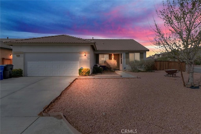 single story home featuring stucco siding, a tile roof, fence, concrete driveway, and an attached garage