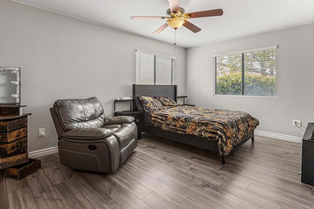 bedroom with a ceiling fan, baseboards, and wood finished floors