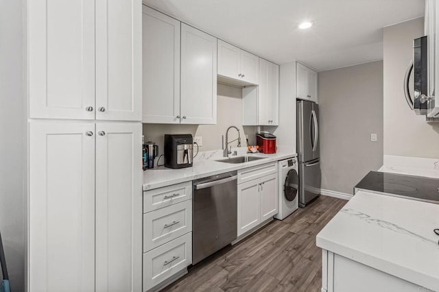 kitchen with washer / clothes dryer, white cabinets, stainless steel appliances, and a sink