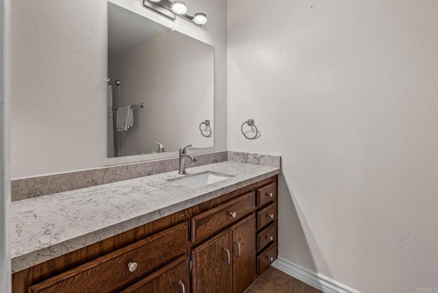 bathroom with tile patterned floors, baseboards, and vanity