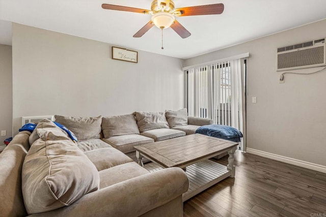 living room with a ceiling fan, wood finished floors, baseboards, and a wall mounted air conditioner