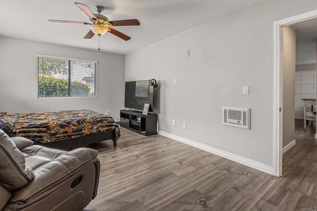 bedroom featuring ceiling fan, visible vents, baseboards, and wood finished floors